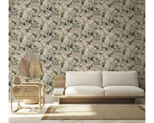 Vardagsrum med blommig tapet, soffa och rottingfåtölj