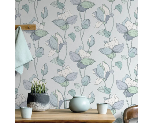 Blommig tapet med tekanna och krukväxt på träbord