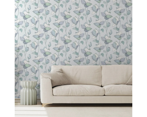 Vardagsrum med mönstrad tapet, soffa och sidobord