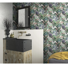 Ett badrum med blommig tapet, ett handfat på en träsockel och en spegel