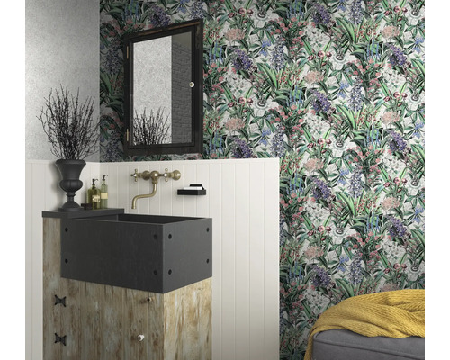 Ett badrum med blommig tapet, ett handfat på en träsockel och en spegel