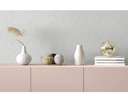 Dekorativa föremål på en skänk framför en mönstrad tapet