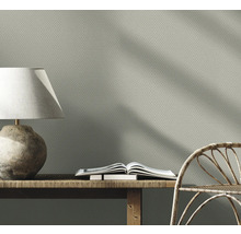Mönstrad tapet i vardagsrum med lampa, bänk och stol