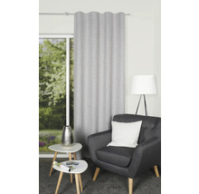 Vardagsrum med gardin, fåtölj, lampa och sidobord