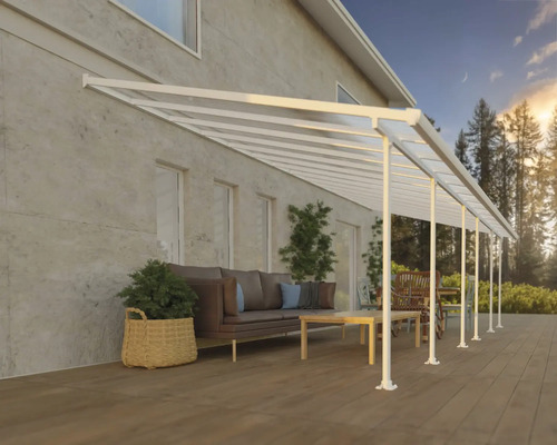 Terrasstak CANOPIA by Palram Feria 4x8,50m vit Terrass med tak och sittgrupp framför ett bostadshus