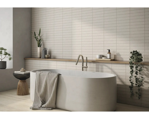 Badrum med badkar, blandare, handduk, hylla och väggplattor