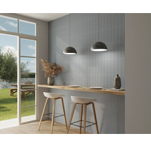 Ljust kök med blå väggplattor, barstolar och utsikt utåt