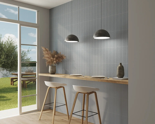 Ljust kök med blå väggplattor, barstolar och utsikt utåt