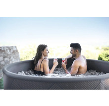 Par kopplar av med drinkar i bubbelpoolen