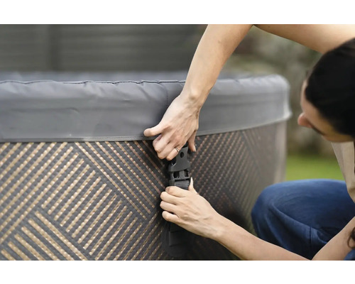 Person som fäster locket på ett spabad med spännen