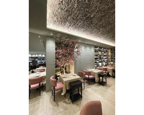 Restauranginteriör med bord, stolar och dekorativ takdesign