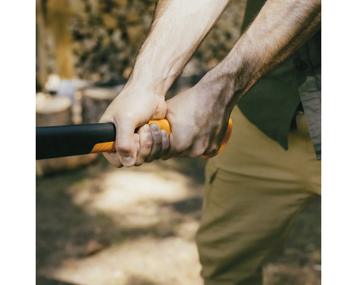 En person håller en yxa med ett plasthandtag.