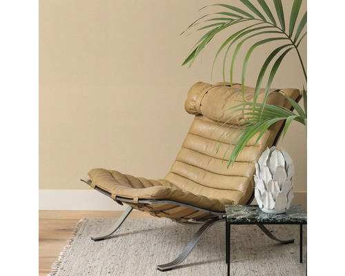 Läderfåtölj med metallram på matta med sidobord och dekoration