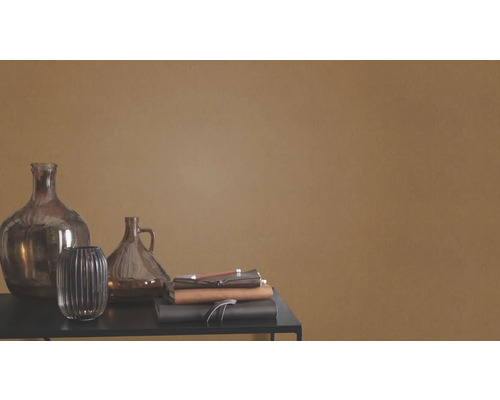 Dekorativa glasvaser och anteckningsböcker på ett bord framför en vägg