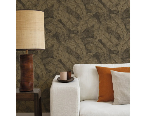 Vardagsrum med mönstrad tapet, soffa, kuddar och lampa