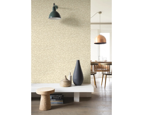 Vardagsrum med mönstrad tapet, vägglampa och dekorativa element.