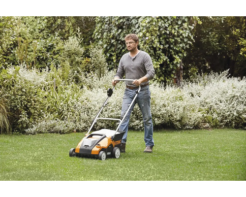 Man använder en gräsmattluftare i trädgården för gräsmattan.