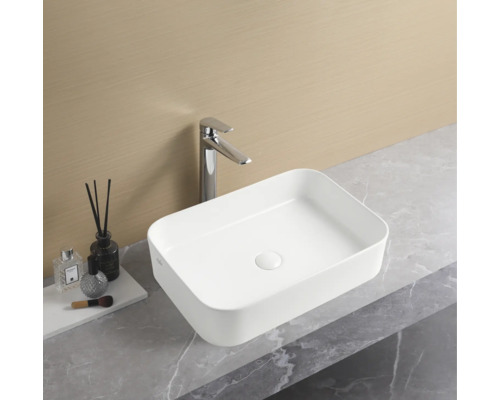 Rektangulärt tvättställ i keramik med blandare på en bänkskiva