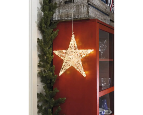 Dekorativ belyst stjärna framför ett skåp