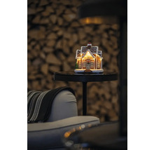 Dekorativt pepparkakshus med belysning på ett bord