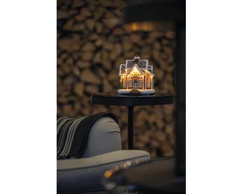 Dekorativt pepparkakshus med belysning på ett bord