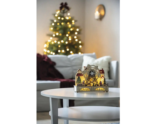 Dekorativ julbelysning med pariserhjul på ett bord i ett vardagsrum med en julgran.