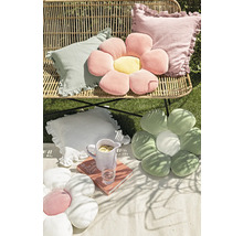 Scen med dekorativa kuddar och en blomsittdyna på en picknickfilt i trädgården