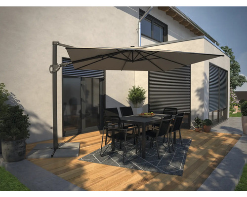Terrass med hängparasoll, bord och stolar framför ett hus.