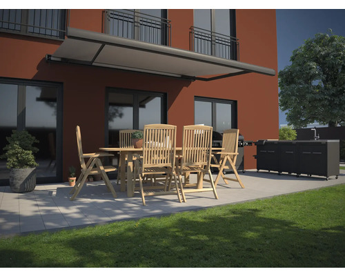 Terrass med markis, trädgårdsbord, stolar och utekök framför ett hus