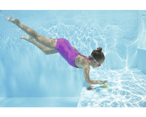 Flicka dyker efter leksaker i poolen