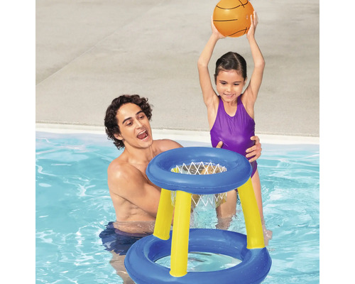 Far och dotter leker med en uppblåsbar basketkorg i poolen.