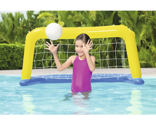 Flicka leker med uppblåsbart vattenpolomål i poolen