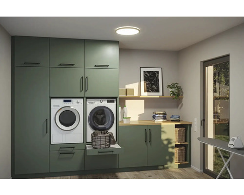 Tvättstuga med tvättmaskin, torktumlare, skåp och strykbräda.