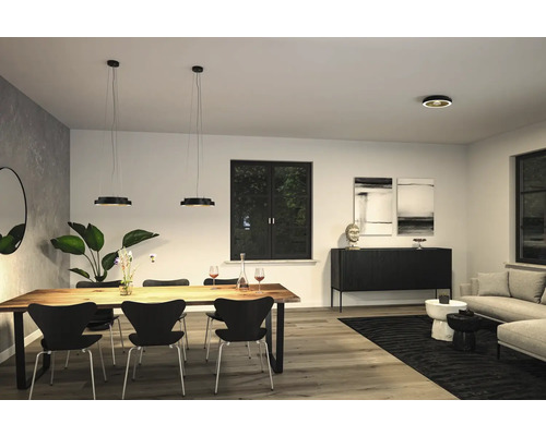 Ljust vardagsrum med träbord, stolar och pendellampor