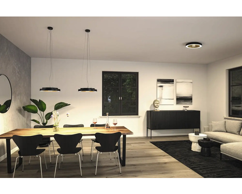 Vardagsrum med matbord, stolar, pendellampor och takspotlights för en modern inredning.