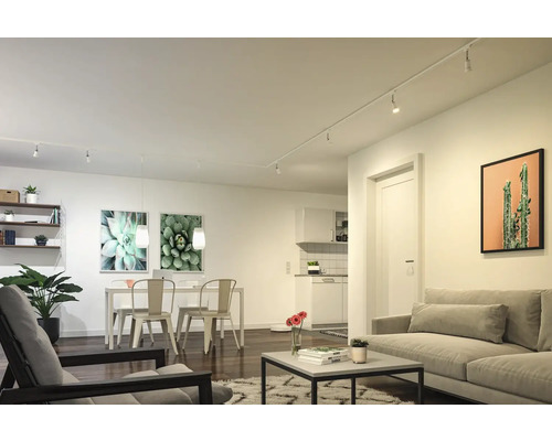 Ljust vardagsrum med soffa, fåtölj, matbord och hyllsystem