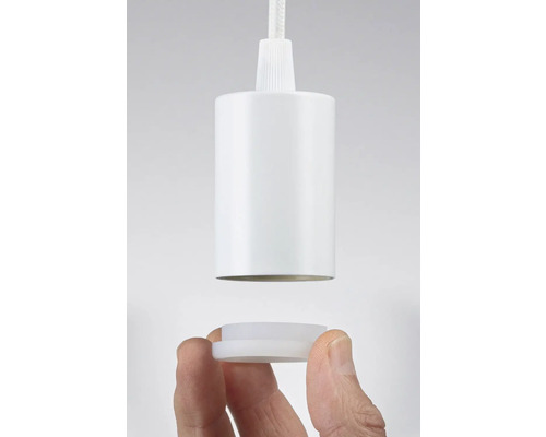 Vit lamphållare hålls av en hand.