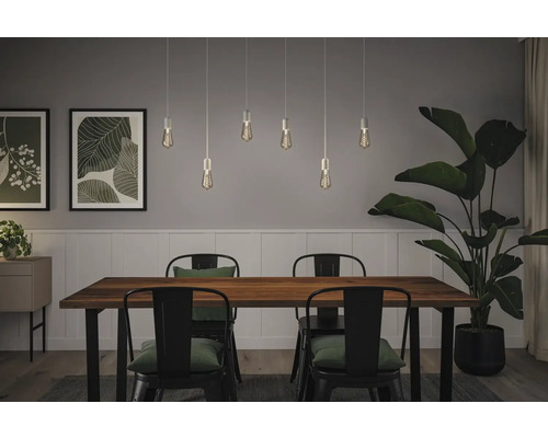 Matsal med träbord, metallstolar och flera hängande lampor