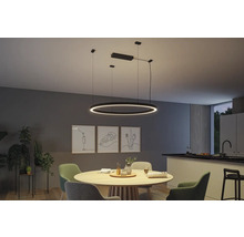 Matsal med modern, ringformad LED-pendellampa över ett runt träbord