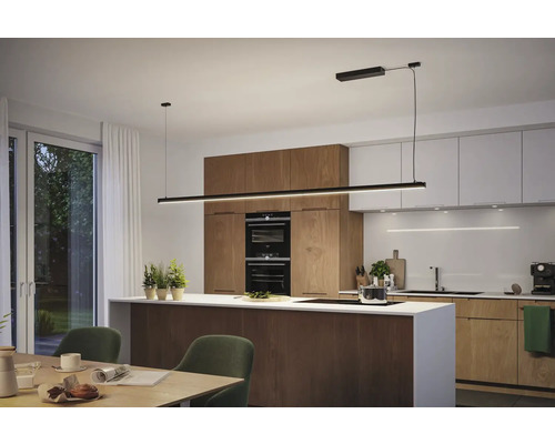 Modernt kök med matbord och en linjär pendellampa ovanför köksön