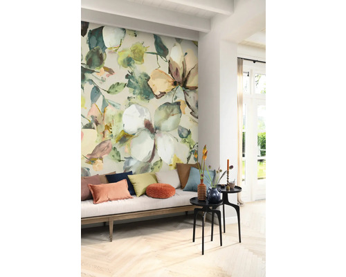 Vardagsrum med blommönstrad tapet, soffa och sidobord