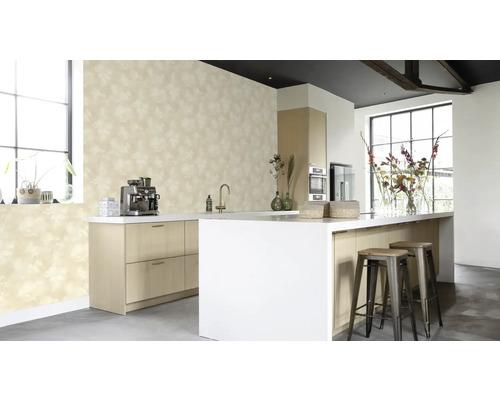 Ljust kök med mönstrad tapet, köksö och barstolar.