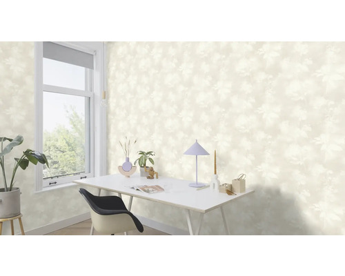Ljust rum med blommönstrad tapet, skrivbord och fönster.