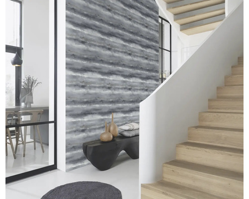 Ljust rum med mönstrad tapet, trappa och bänk