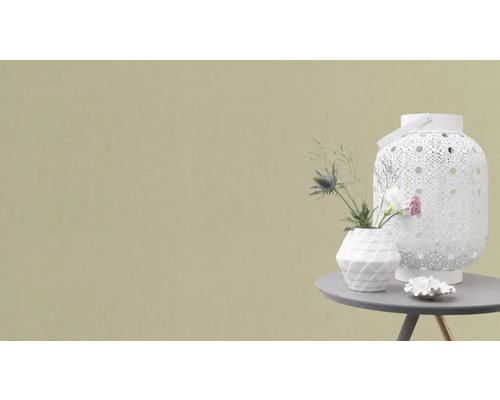 Dekorativ scen med lykta, vas och blomsterarrangemang på ett bord.