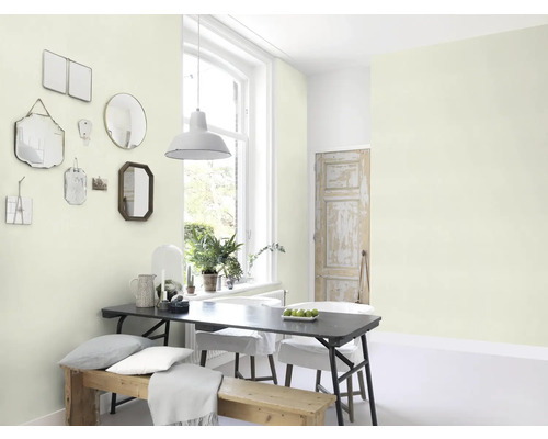 Ljust rum med matbord, stolar, bänk och speglar på väggen