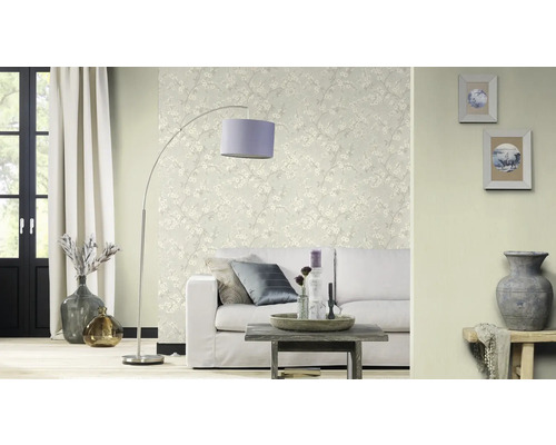 Vardagsrum med soffa, golvlampa och blommig tapet för en ljus atmosfär