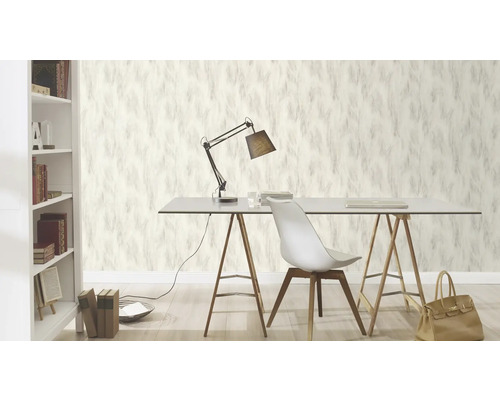Scen av ett arbetsrum med tapet med fjäderdesign, skrivbord, lampa och bokhylla.