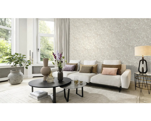 Ljust vardagsrum med mönstrad tapet, soffa och soffbord.