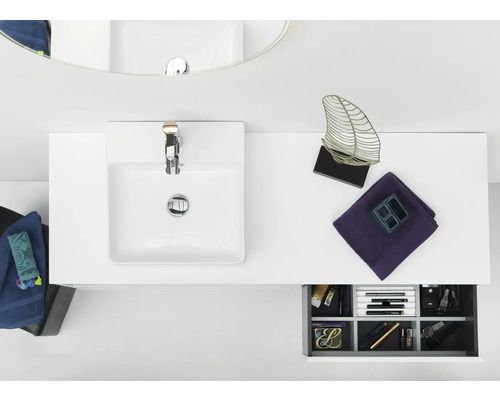 Badrum med handfat, blandare, spegel och låda med kosmetika